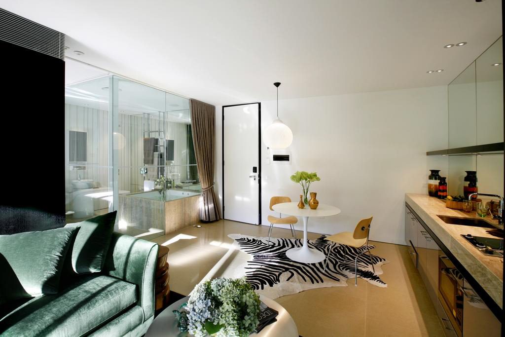 Interior of Green and Beige Decor Villa, View from lounge leading to kitchenette, dining with view of king spa and floor to ceiling glass walled bathroom.